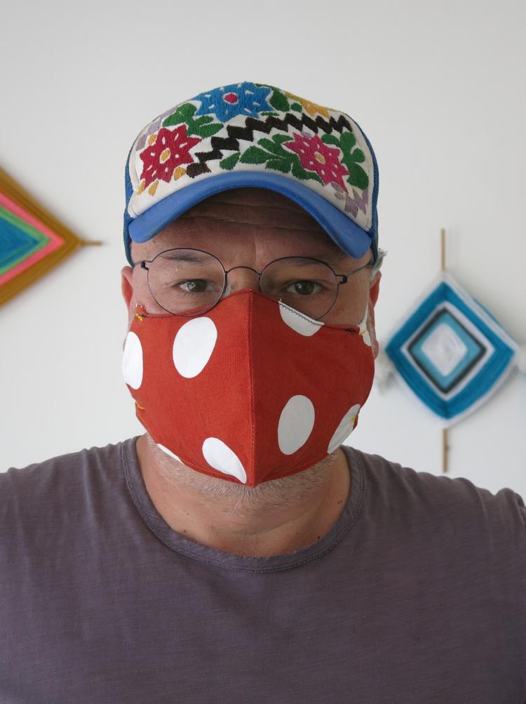 portrait de Frédéric Fonteyne avec une casquette et un masque rouge à pois blancs