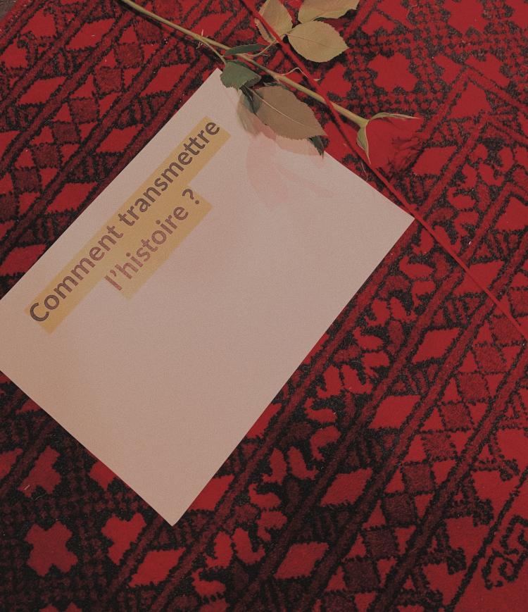 carton blanc sur un tapis et une rose rouge 